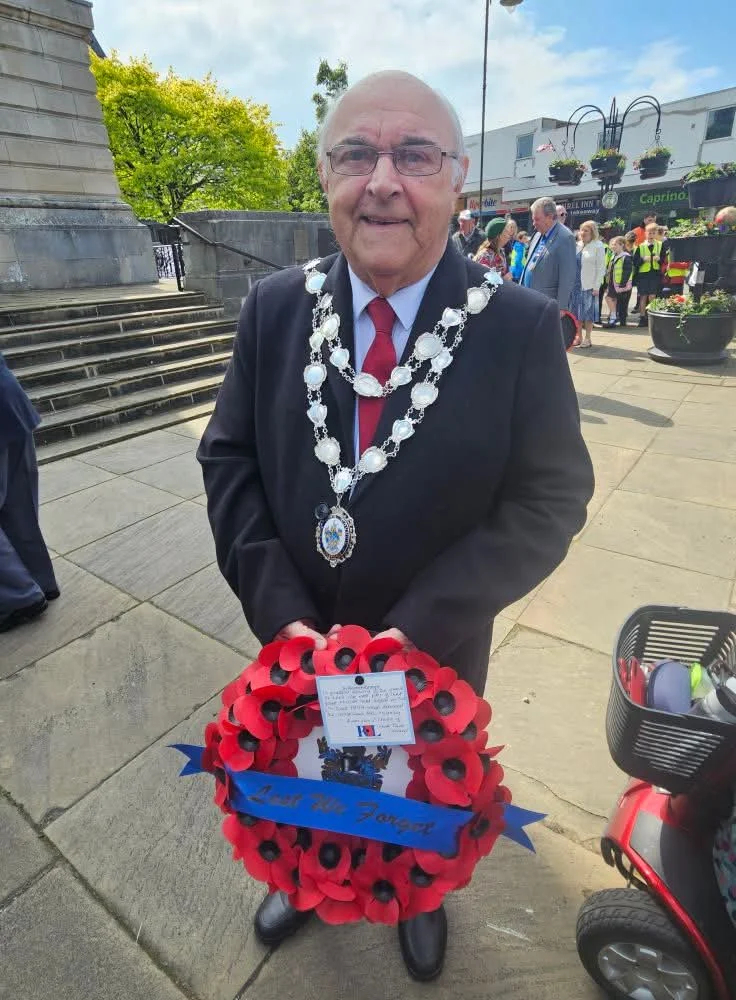 Barry Birch wearing his mayoral chain and holding a remembrance wreath